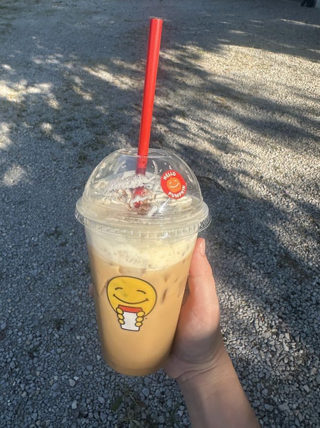 Scooter’s iced pumpkin latte with red straw and creamy foam at top