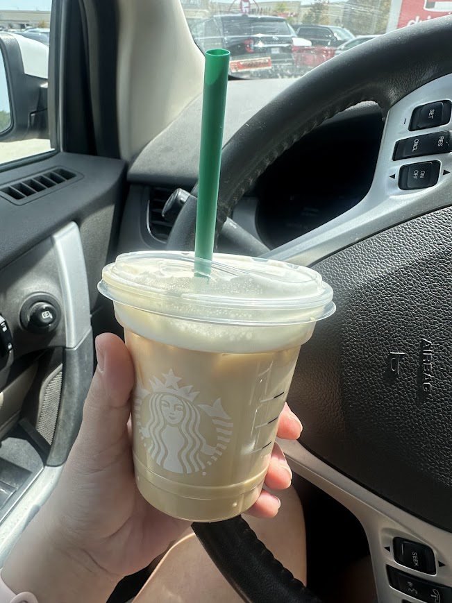 Close-up of Starbucks iced pumpkin spice latte in a plastic cup with green straw